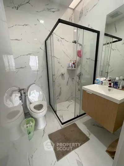 Modern bathroom with glass shower and sleek fixtures in a stylish home.