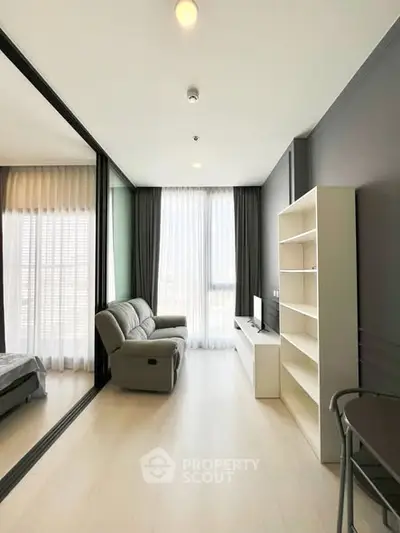 Modern living room with sleek design, featuring a cozy sofa, large window, and stylish shelving unit.