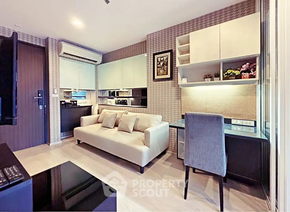 Modern living room with stylish decor and integrated kitchen area, featuring a cozy sofa and workspace.