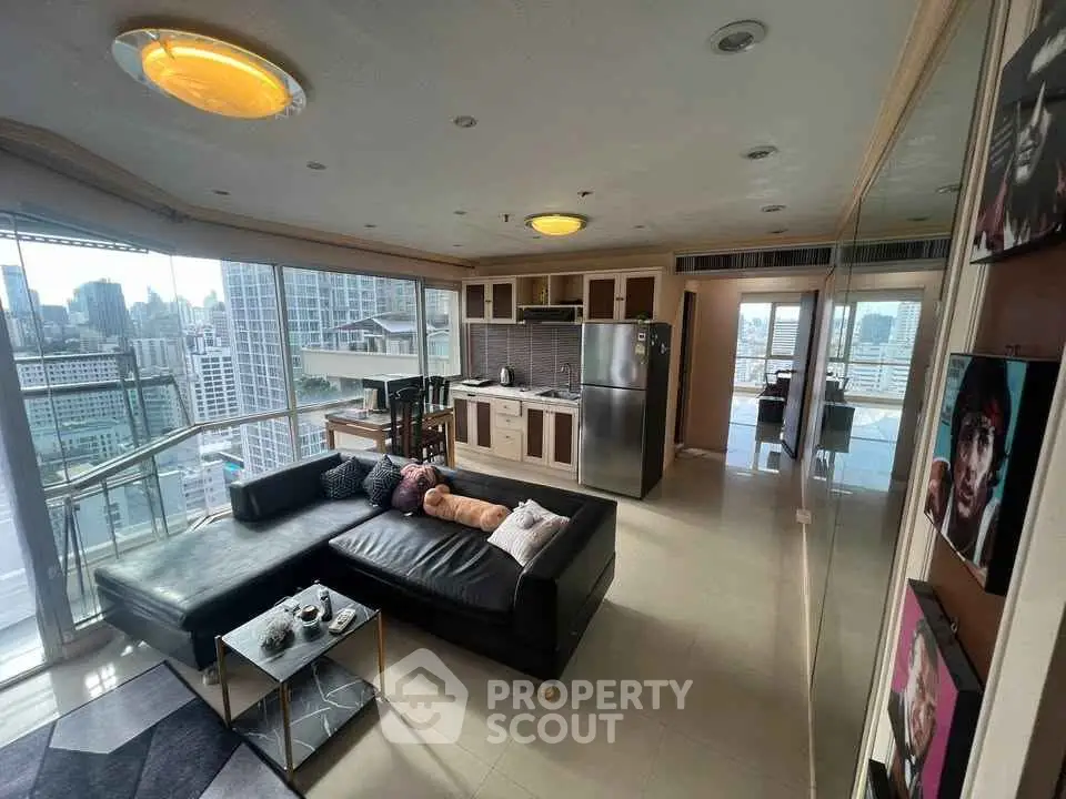 Spacious modern living room with city view, open kitchen, and stylish decor in high-rise apartment.