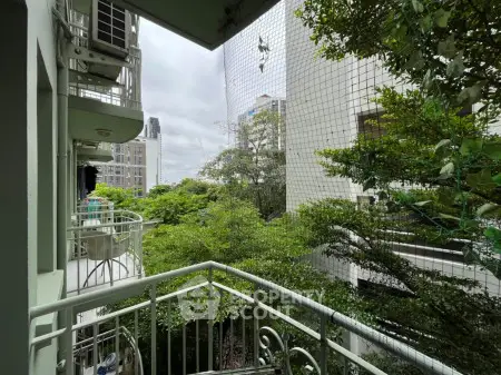 Charming balcony with lush greenery and city view, perfect for relaxation and enjoying nature.