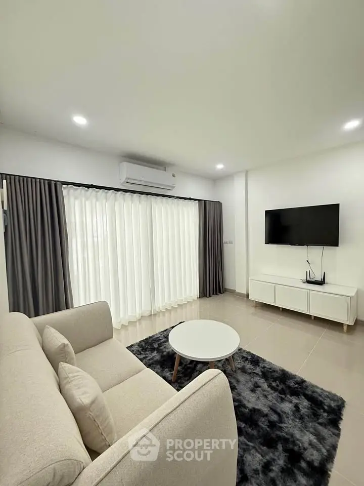 Modern living room with sleek furniture and large windows for natural light.