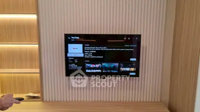 Modern living room with wall-mounted TV and stylish wood paneling