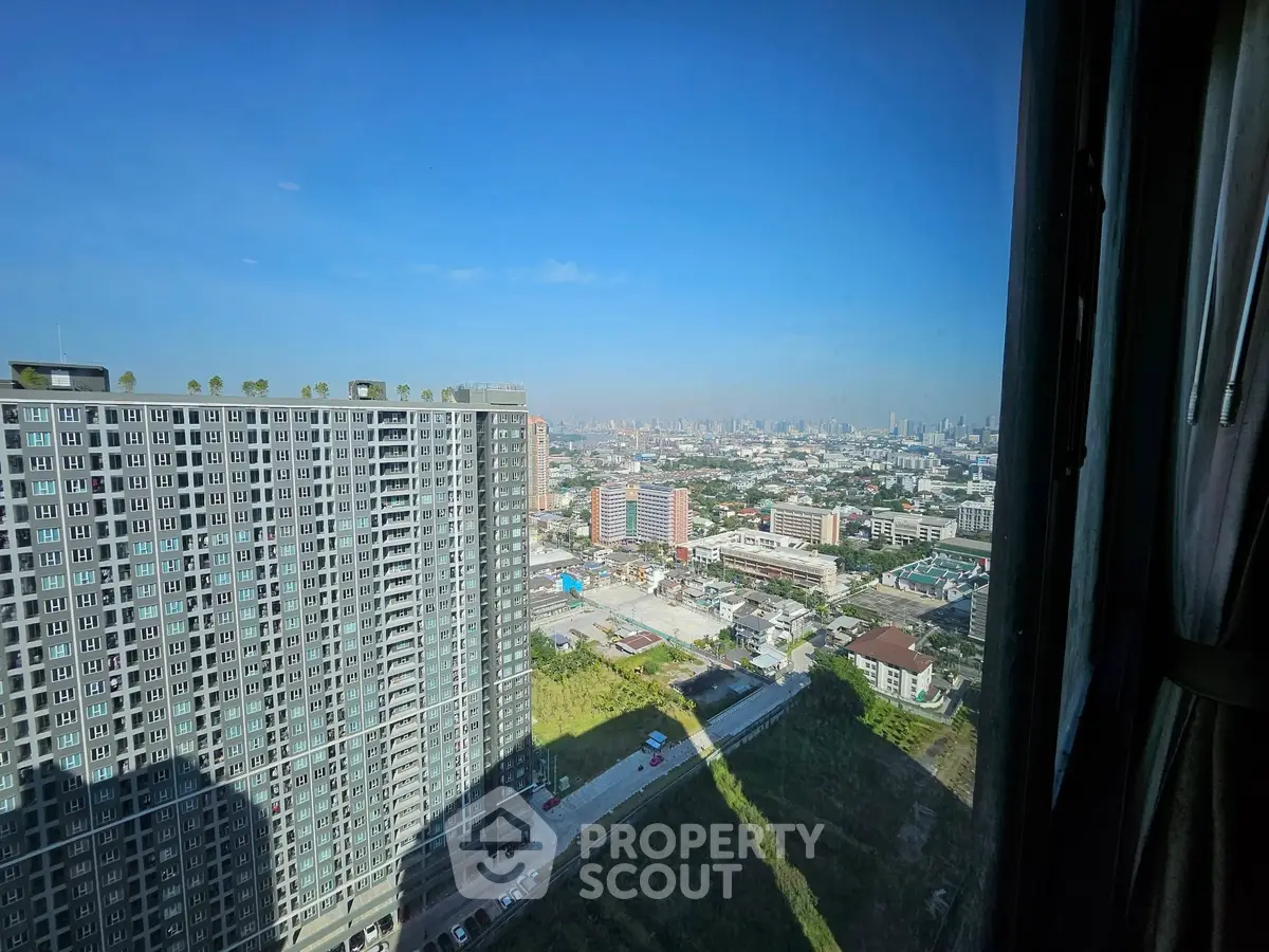 Stunning cityscape view from high-rise apartment window, showcasing urban skyline and modern architecture.