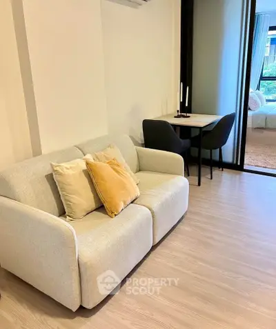 Cozy living room with modern sofa and dining area, perfect for urban living.