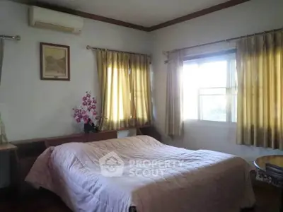 Cozy bedroom with natural light and elegant decor, featuring a comfortable bed and stylish curtains.