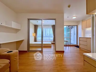 Spacious modern apartment with open layout and wooden flooring, featuring a cozy bedroom and stylish living area.