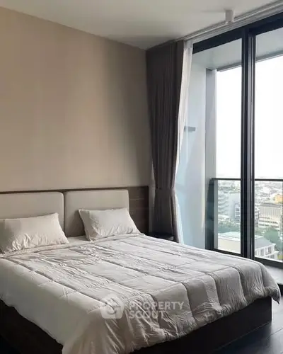 Modern bedroom with large windows offering stunning city view