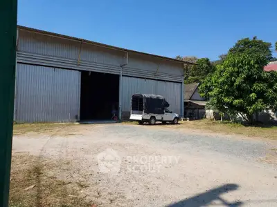 Spacious industrial warehouse with large open entrance and ample outdoor space.
