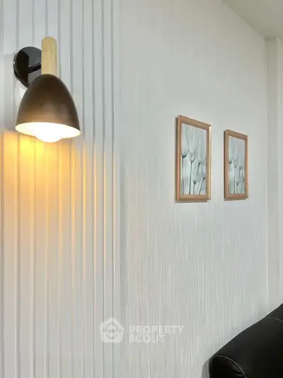 Modern living room with stylish wall lamp and framed art decor