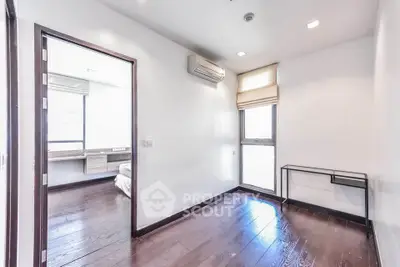 Bright and airy bedroom with wooden flooring and air conditioning in modern apartment.