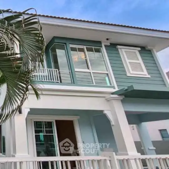Charming two-story house with modern design and lush greenery, perfect for family living.
