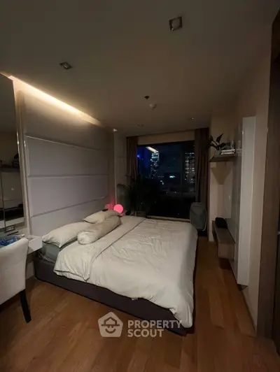 Luxurious bedroom with city view, modern decor, and cozy ambiance.
