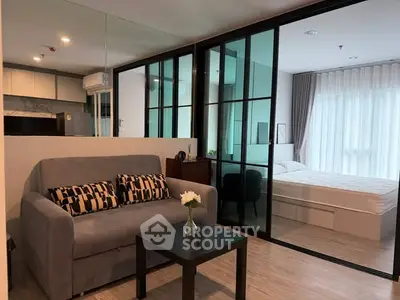 Modern studio apartment with glass partition, cozy living area, and stylish decor.