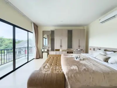 Luxurious bedroom with large windows and balcony access, featuring elegant decor and ample natural light.