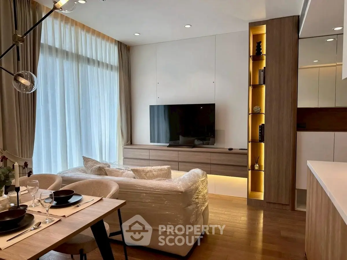 Modern living room with elegant decor and large windows, featuring a cozy dining area and stylish lighting.