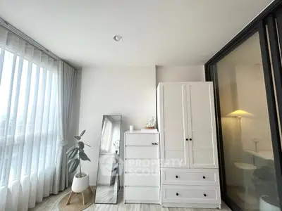 Bright modern bedroom with white furniture and large window