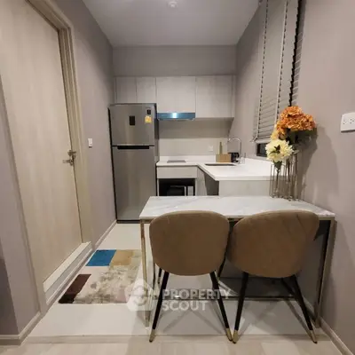 Modern compact kitchen with sleek design and dining area in a stylish apartment.