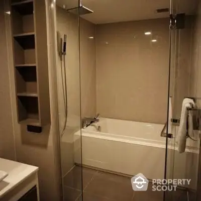 Elegant bathroom with glass shower and built-in bathtub, modern fixtures, and neutral tiled walls for a serene spa-like experience.