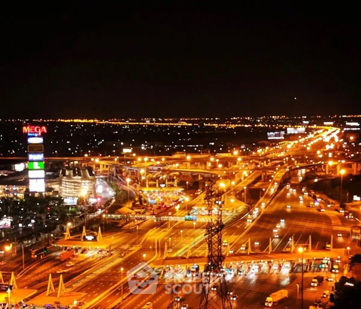 Stunning night view of cityscape with illuminated highways and vibrant lights.