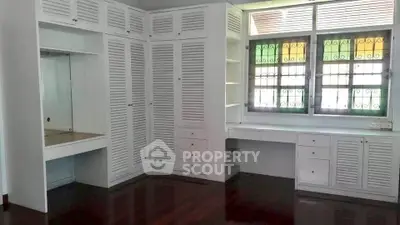 Spacious bedroom with built-in white closets and large window, perfect for natural light lovers.