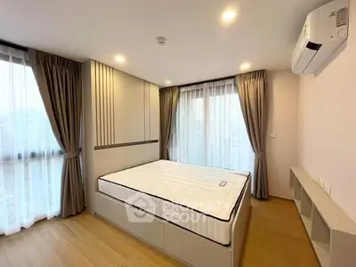 Modern bedroom with large windows, stylish curtains, and air conditioning unit.