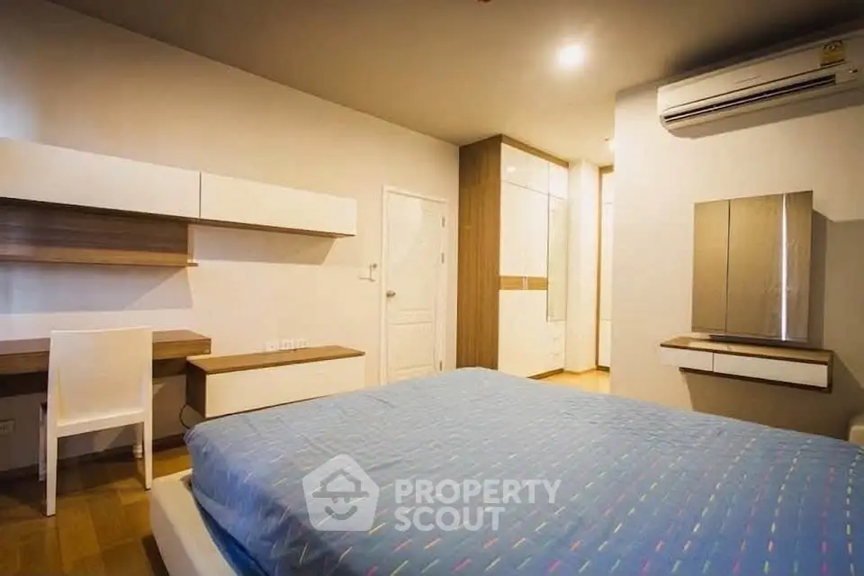 Spacious modern bedroom with sleek furniture and air conditioning, perfect for comfort and style.