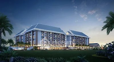 Majestic multi-story residential building at dusk with illuminated windows and lush greenery, offering a luxurious living experience in a serene environment.