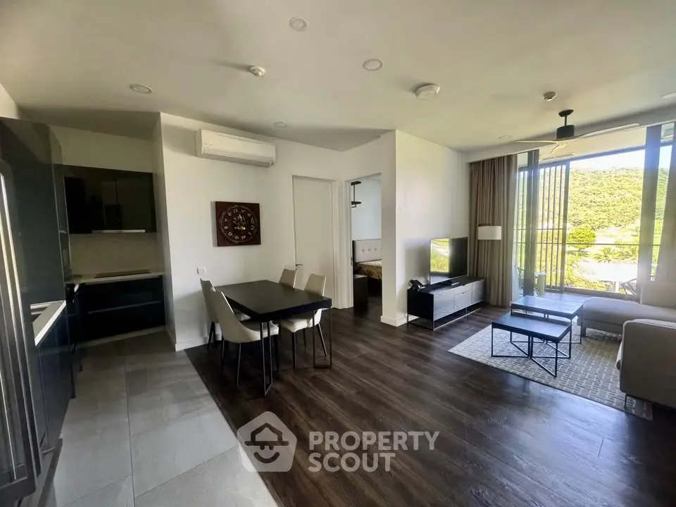 Modern open-plan living room with dining area and scenic balcony view