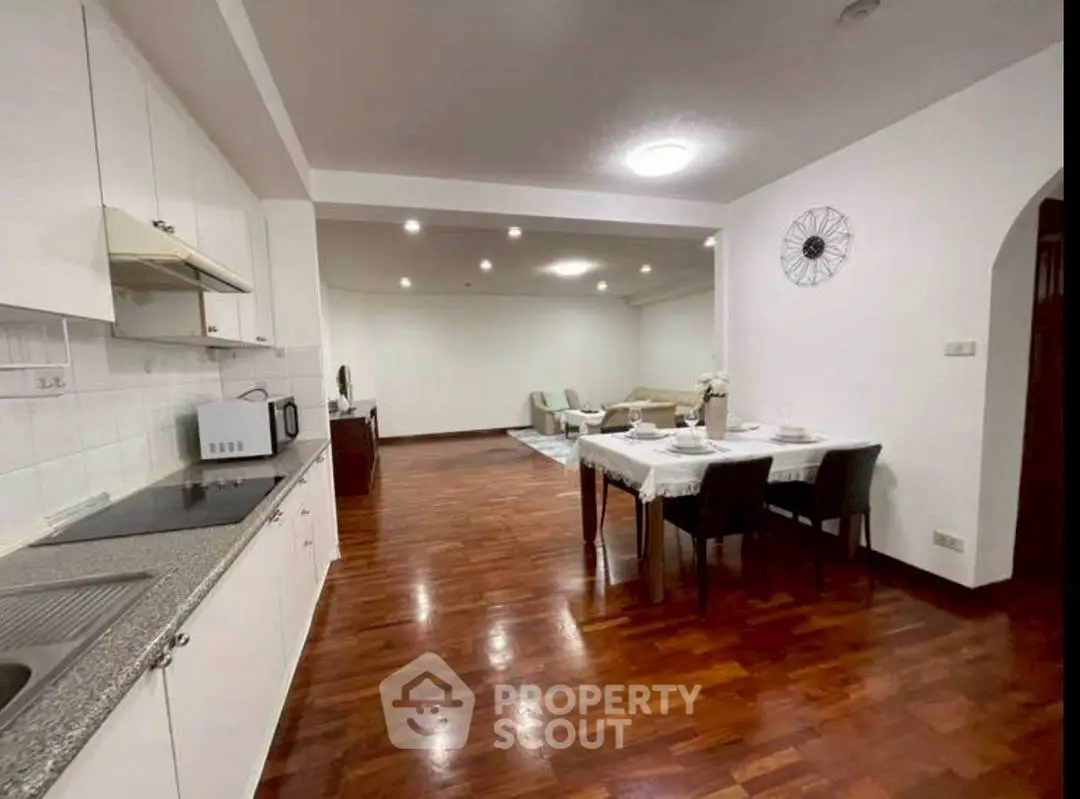 Spacious open-plan kitchen and living area with elegant wooden flooring.