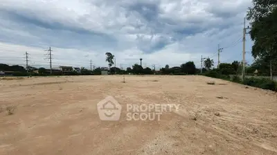 Expansive vacant land with development potential under a cloudy sky, ideal for investment opportunities.