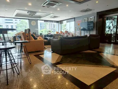 Spacious modern living room with elegant furniture and large windows offering city views.