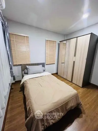 Cozy bedroom with wooden flooring and modern wardrobe design