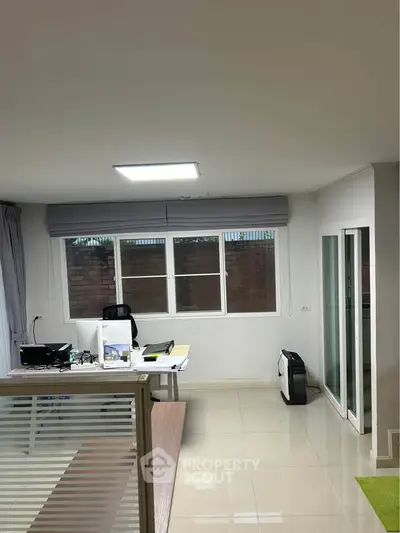 Modern study room with sleek desk and large window, ideal for productivity and comfort.