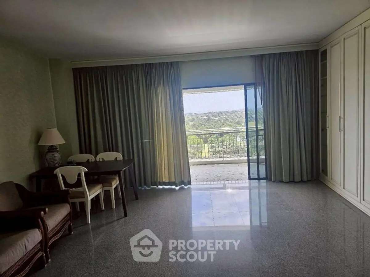 Spacious living room with large windows and balcony view