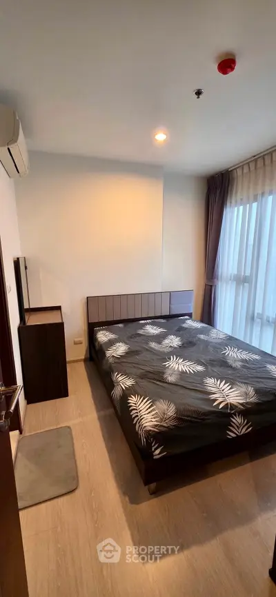 Modern bedroom with stylish decor and large window for natural light