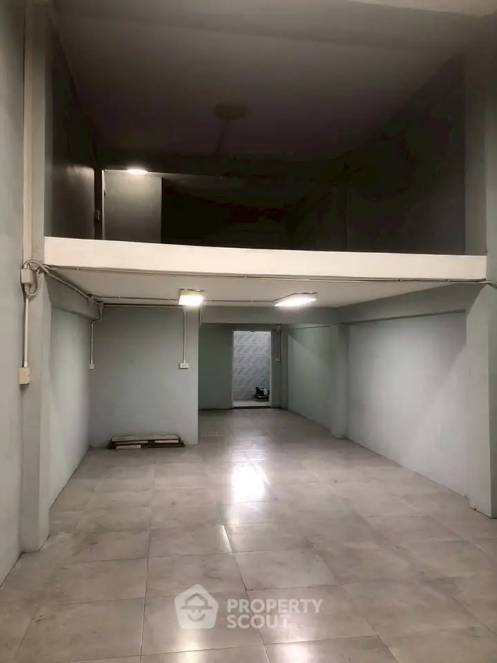 Spacious industrial-style interior with high ceilings and mezzanine level, ideal for creative workspace or storage.
