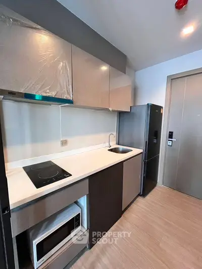 Modern kitchen with sleek cabinetry, built-in appliances, and minimalist design in a contemporary apartment.