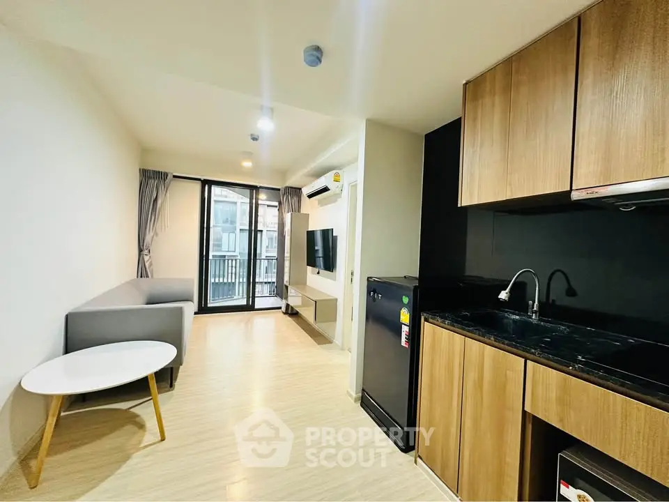 Modern living room with open kitchen and balcony view in stylish apartment