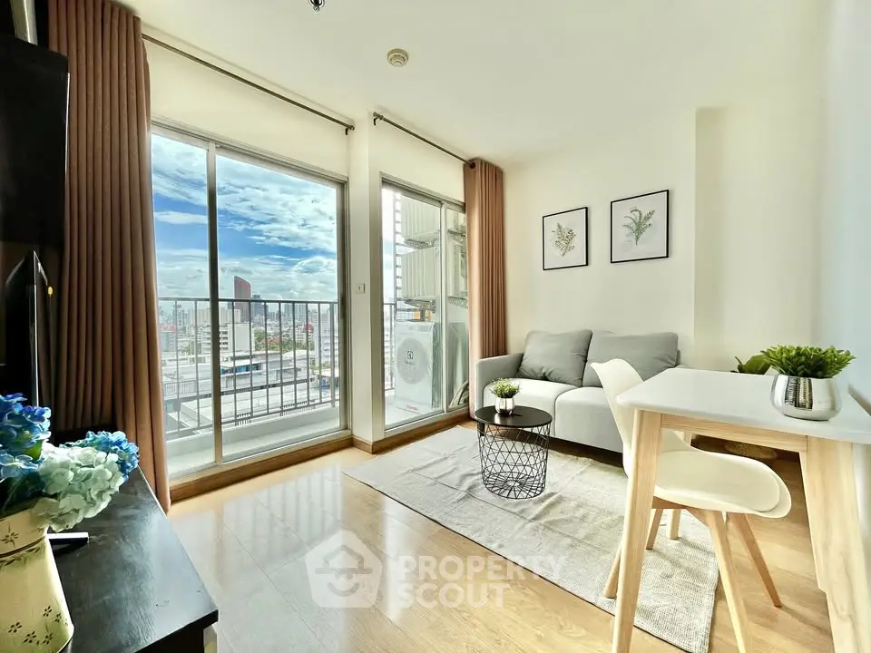 Bright modern living room with balcony and city view, featuring cozy furniture and stylish decor.