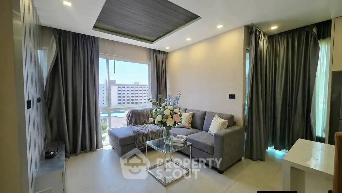 Modern living room with elegant decor and large windows offering natural light.