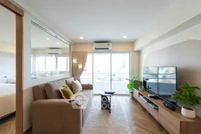 Modern living room with large window, stylish furniture, and natural light.