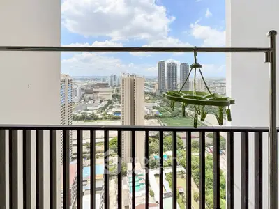 Stunning high-rise balcony view with cityscape and clear skies, perfect for urban living enthusiasts.
