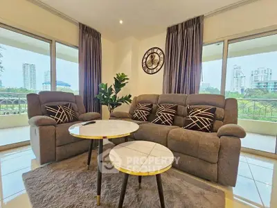 Spacious living room with modern furniture and city view, perfect for relaxation and entertainment.
