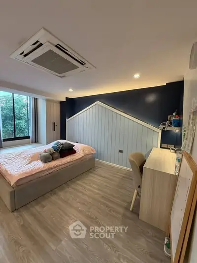 Modern bedroom with unique wall design and large window view.