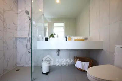 Modern bathroom with sleek design, glass shower, and elegant fixtures in a luxury home.
