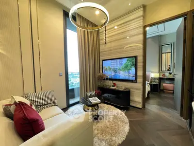 Luxurious living room with modern decor and large TV, adjacent to a cozy bedroom.