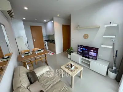 Modern living room with open kitchen and cozy dining area in a stylish apartment.