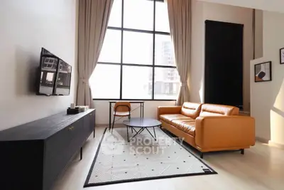 Modern living room with large window, leather sofa, and stylish decor