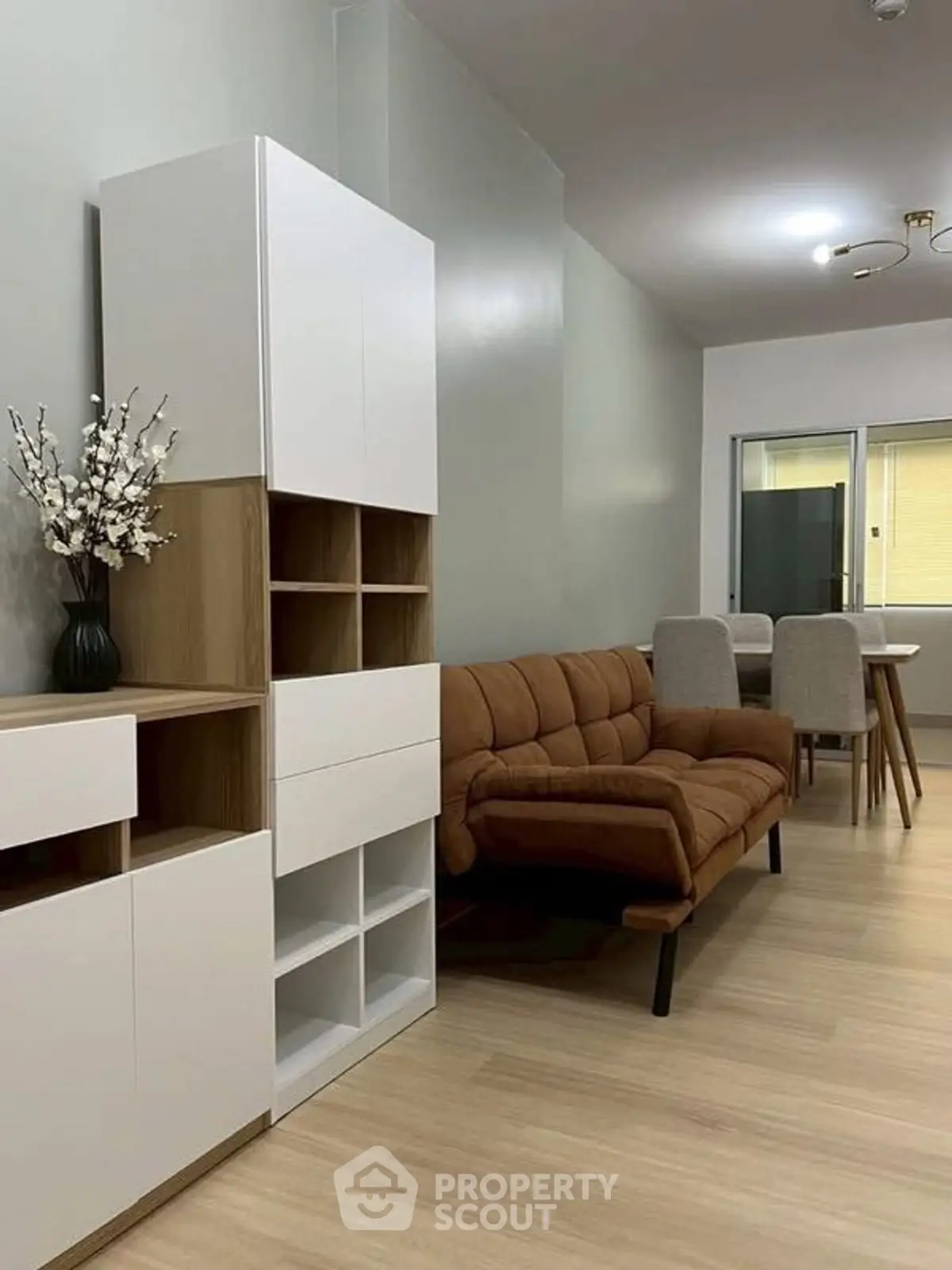 Modern living room with stylish furniture and dining area in open layout apartment.